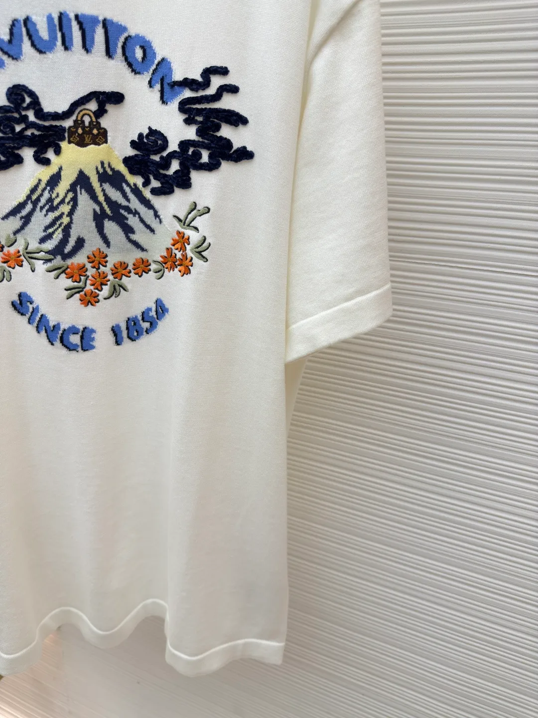LOUIS VUITTON Nigo co-branded volcano embroidered knitted short-sleeved T-shirt ●Authentic product: Purchased and developed for 10999 ●Item number: 1680108-A90 ●Fabric: Pure cotton ribbed fabric ●Technology: Knitted production ●Version: Fitted version ●Weight: about 240 grams ●Size: XS-S-M-L ●Description: Pharrell William and Nigo dance together at the autumn and winter show. A Monogram handbag emerges from a volcano, surrounded by Louis Vuitton elements and cherry blossoms. This image is intarsia and embroidered on the chest of this sweater. Short-sleeved T-shirts for men and women cut from soft cotton in a round-neck style. The overall wiring is straight and delicate, the fabric is comfortable and soft, and the color is consistent without color difference. It can be matched with the same style to create a fashionable look and control various occasions. Customized accessories, complete with three standards, same style for men and women!